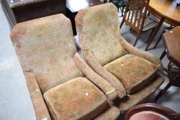 A pair of Barker & Stonehouse easy chairs, with footstools, in need of upholstery