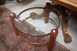A circular two-tier yewwood and glass coffee table, the clear glass top with textured edge detail