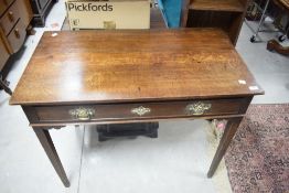 A George III oak low/boy/side table of rectangular form with long freize drawer over tapering square