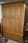 A modern pine double wardrobe having drawer base, approx. Dimensions W131 D59 H196cm