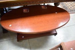A reproduction mahogany effect oval coffee table 49cm x 118cm