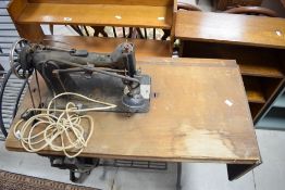 A Singer treadle sewing machine with cast treadle base, appears to have been later converted to