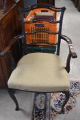 An early 20th Century mahogany framed carver chair having scroll arms and shaped ladder back