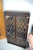 A Old Charm/Priory style bookcase having lead effect glazed door and linen fold decoration to