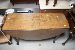 A 19th century oak drop-leaf dining table, with demi-lune leaves and turned legs with pad feet