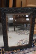 A late 19th or early 20th Century wall mirror having carved oak frame and bevelled edge. Approx.