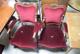 A pair of part upholstered French style his and hers low armchairs, with foliate carved crest-rails,