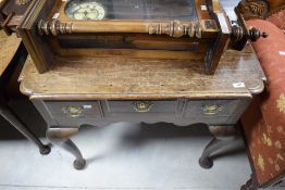 A George III oak lowboy, having a moulded rectangular top above three short drawers, shaped apron