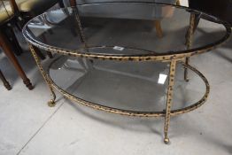 A modern wrought iron and glass two tier coffee table having gilt finish, width approx. 100cm