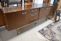 A vintage (mid century modern) walnut sideboard having cupboard and drawer sections, including