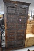 A rustic Indian style cabinet having shelved interior, approx. H185 W89 D43cm
