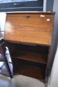 An early 20th Century oak shallow bureau with bookshelf under, width approx. 55cm