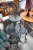 A vintage cast alloy garden set comprising circular bistro table and four chairs