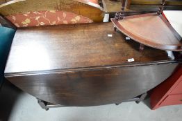 A 19th century oak drop-leaf gate-legged table, having demi-lune flaps and turned supports 70cm x