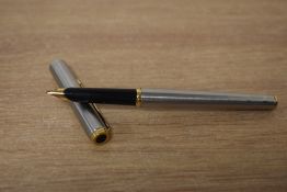A Parker Arrow aerometric fountain pen in brushed steel with gold trim.