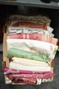 A quantity of fabrics in a range of patterns and fibres, including florals, flecked cotton, silver