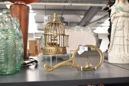 A small brass Art Nouveau style handheld vanity mirror sold together with a small vintage brass bird