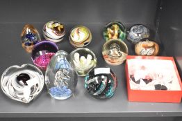 A group of twelve Caithness and similar glass paperweights