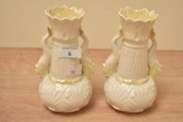 A pair of vintage Belleek porcelain dolphin spill vases, measure 16cm tall respectively.