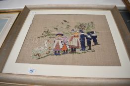 Two framed hand-made embroideries, one depicting a railway station scene with family and dog, in a