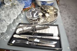 A quantity of silver plated cutlery, to include a pair of candlesticks, a lidded tureen, and a sugar