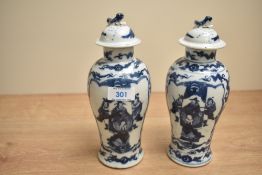 A pair of Chinese blue and white porcelain baluster-shaped lidded vases, having Foo dog finials to