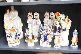 A large assortment of Staffordshire pottery flat back and other figures, including largest