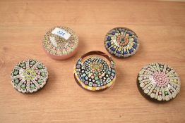 A group of five Perthshire and similar glass paperweights.
