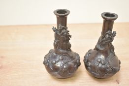 A pair of Japenese bronze vases, likely Meiji period, featuring dragon and flower motifs, measure