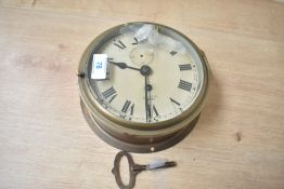 A ship's brass wind up bulkhead clock with Roman numerals, diameter measures 16cm, complete with