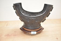 A metal Chinese archaic style bowl raised on a wooden base, L27cm