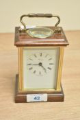 A brass cased Henley carriage clock, the dial with Roman numerals, measures 12cm tall.