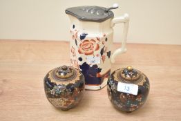 A pair of small Chinese cloisonné enamel lidded jars raised on tripod feet sold together with a