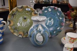 Two studio pottery decorative plates both having floral designs to centre sold alongside a studio