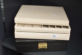 A large cream coloured stackable jewellery box sold together with a similar sized brown jewellery