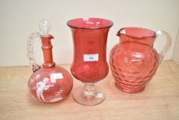 A trio of Cranberry glass to include a Mary Gregory decanter measuring 20cm tall.