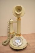 A vintage rotary candlestick telephone in cream, measures 32cm tall.