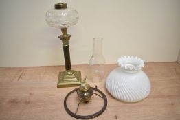 A brass column oil lamp having spirally fluted milk glass shade, glass reservoir complete with