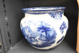 A large blue and white porcelain jardinaire depicting temple like buildings to mid-section,