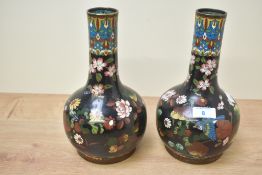 A pair of Chinese cloisonné enamel vases, of onion form having floral design to dark background with