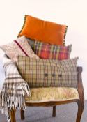 A collection of warm toned soft home furnishings comprising a James Pringle Weavers wool mix throw