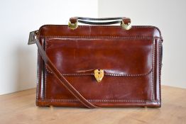 A vintage Roland Cartier designer handle bag in smooth patent oxblood leather, with detachable cross