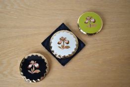 Three 1950-1970s Stratton compacts with the Orchid transfer design. The two Stratton Convertible