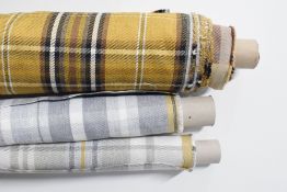 Four bolts of plaid fabrics in cotton and wool blends, in mustard, white, greys and browns, each