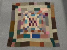 A vintage wool patchwork quilt arranged in a brickwork design on both sides, showcasing tweeds,
