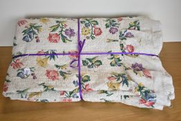 A 1940s vintage quilted bedspread in multicoloured floral design on a woven beige background,