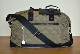 A Steve Madden hold-all / duffel bag in quilted green khaki nylon, with silver metal hardware, black