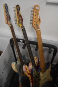 Three psychedelic themed electric guitars, and guitar stand
