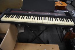 A Roland EP-77 digital piano , with folding metal stand and original cardboard box