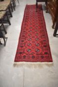 An Afghan runner having red ground, approx 300 x 73cm